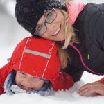 Jeune maman jouant avec son enfant dans la neige heureuse d'avoir immigrer au Canada avec sa familleimmigrante-Canada