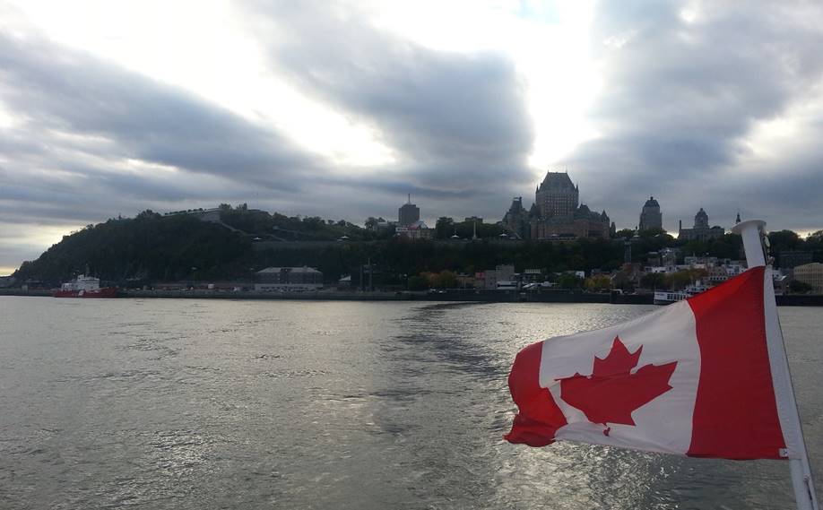 le drapeau canadien avec vue sur la ville de Québec qui symbolise l'immigration au Canada