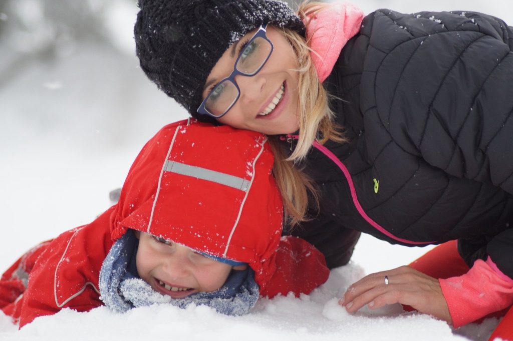 Jeune maman jouant avec son enfant dans la neige heureuse d'avoir immigrer au Canada avec sa familleimmigrante-Canada